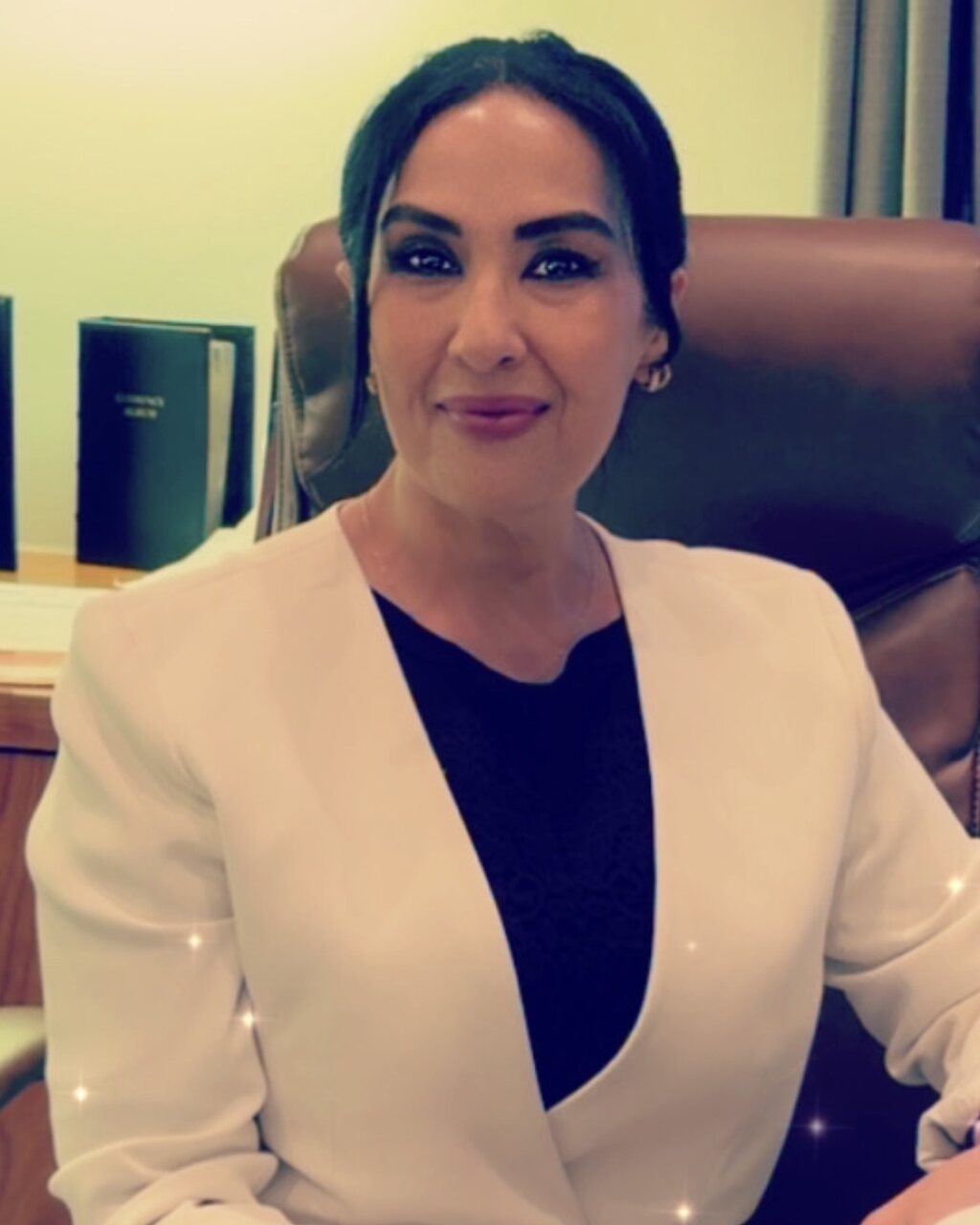 Dr. Kerri, seated at her desk in a white jacket, smiling at the camera